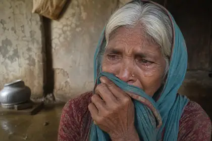 An elderly woman crying after the flood