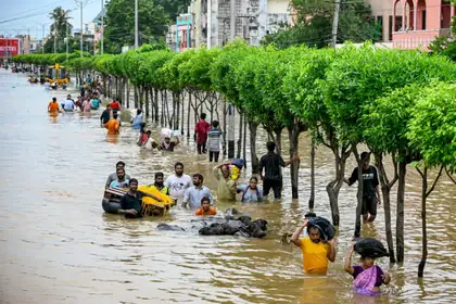 People walking through a flooded street