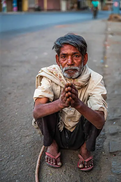 An old man on the pavement, asking the day to be gentler