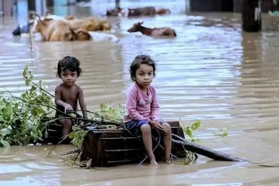 Two children waiting on a crate after the water rose