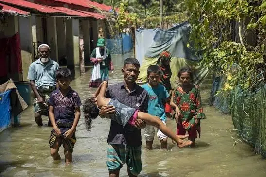A father carrying his child through the flood lane